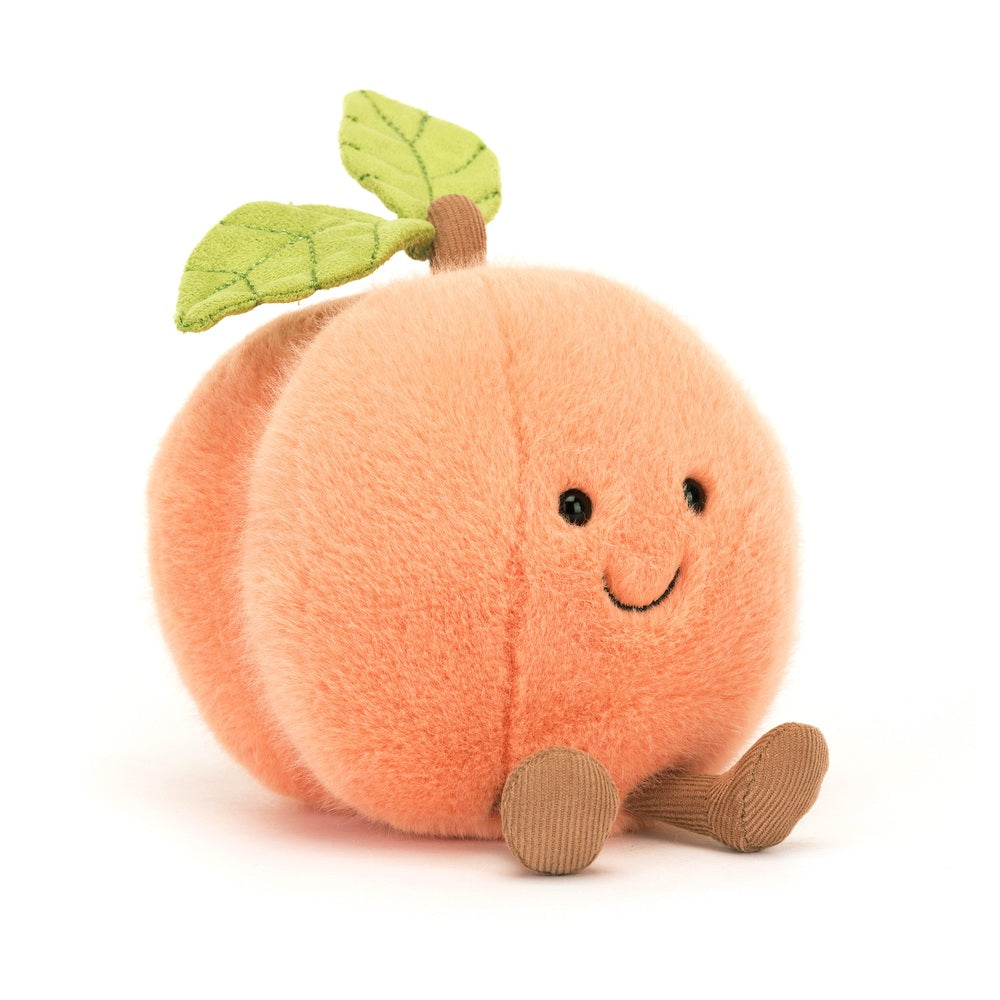 Amuseables Peach is a soft, plush toy shaped like a smiling peach with fabric leaves on top and small brown fabric legs, perfect for toddler play and kids' gifts.