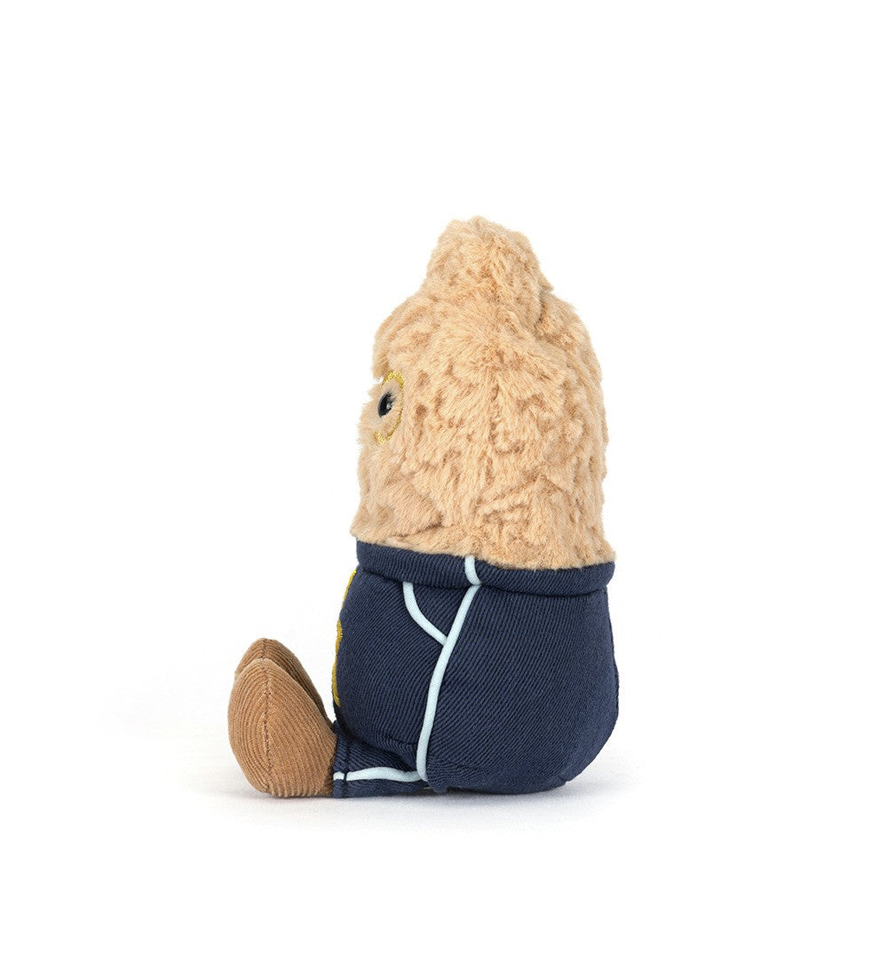 Soft plush toy dressed in a navy blue outfit with light blue trim, designed as the Amuseables Peanut Star Student Outfit, sitting upright with textured beige fabric.