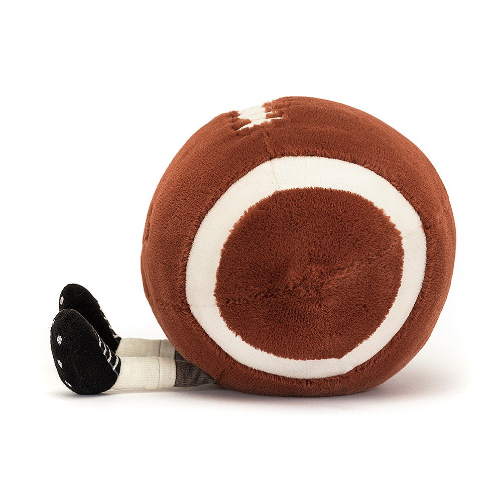 Soft plush toy resembling a brown football with white laces and stripes, featuring small legs wearing black shoes, designed as Football Sports Amuseables.