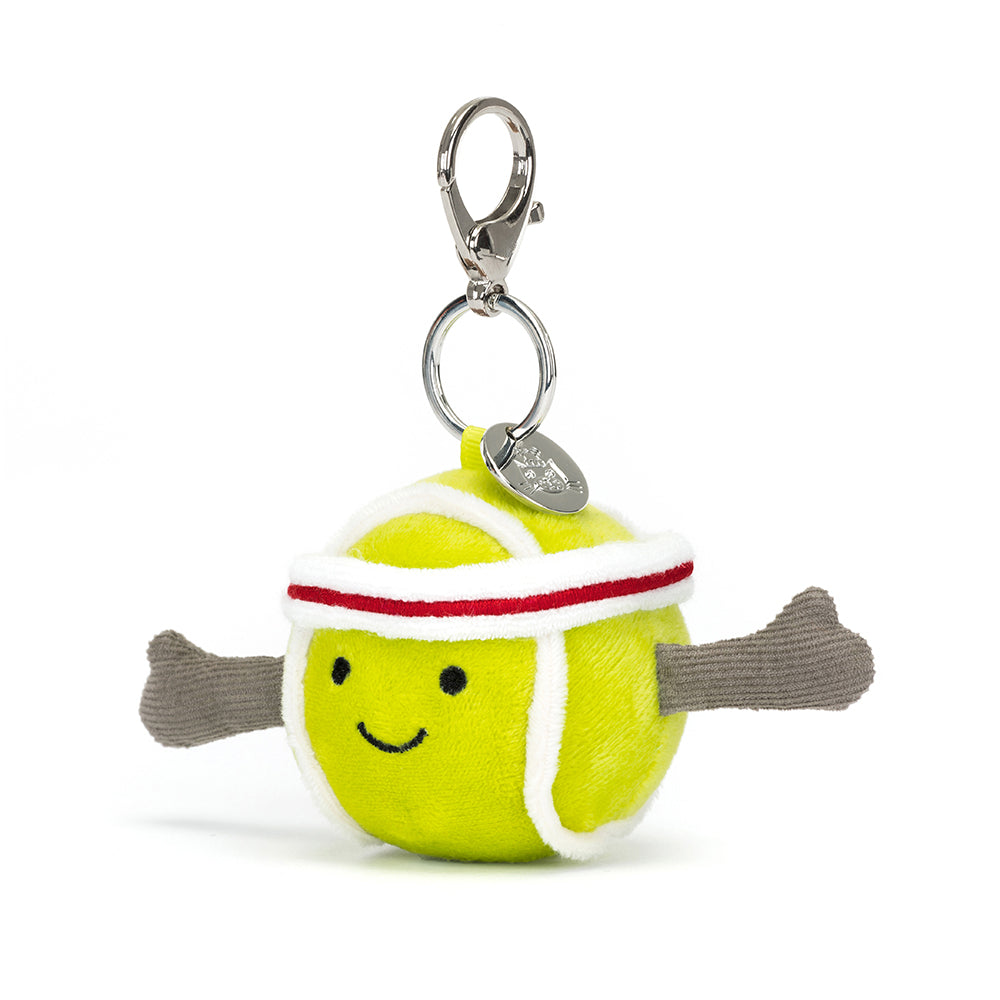 Cute plush tennis ball with a happy face, wearing a sporty headband and extended arms, attached to a metal clasp keychain for the Sports Tennis Bag Charm.