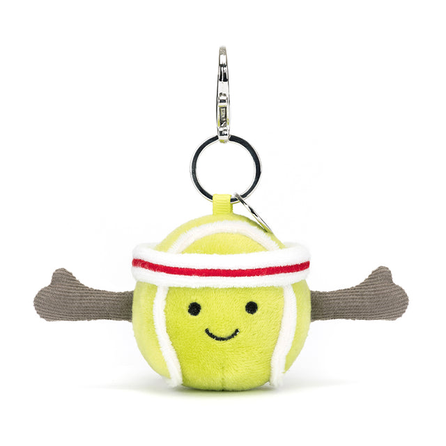 Soft plush tennis ball with a smiling face, wearing a white and red headband and featuring extended brown arms, attached to a metal keyring for the Sports Tennis Bag Charm.