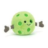 A soft green plush toy with cheerful embroidered facial features and brown glove-like hands, resembling a pickleball character named Amuseables Sports Pickleball.