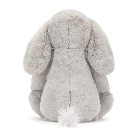 Back view of a soft, plush gray stuffed animal with long ears and a tufted tail, representing the Bashful Luxe Elephant Thuddeus Huge plush toy.