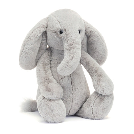 Soft gray plush elephant with large floppy ears and a long trunk sitting upright, a cozy and cuddly Bashful Luxe Elephant Thuddeus Huge perfect for toddlers and kids.