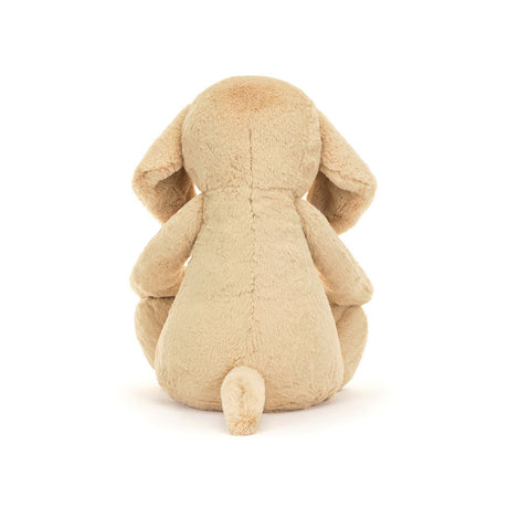 Soft beige plush puppy stuffed animal sitting with back facing forward, showcasing floppy ears and small tail, named Bashful Luxe Puppy Orlando Huge.
