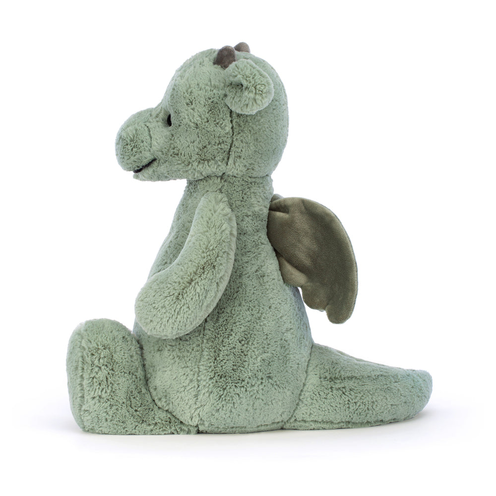 Side view of a soft, green plush toy with wings, horns, and a tail, named Bashful Dragon Really Big, designed as a cuddly stuffed animal for children.