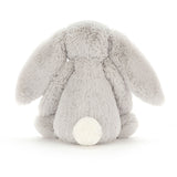 Soft plush Bashful Silver Bunny Medium sitting with its back facing forward, showing its fluffy tail and long ears, perfect as a baby toy or stuffed animal.