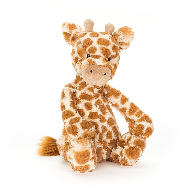 Soft plush Bashful Giraffe toy with orange and white spotted fur, sitting with a friendly expression, designed for comforting play and cuddles.