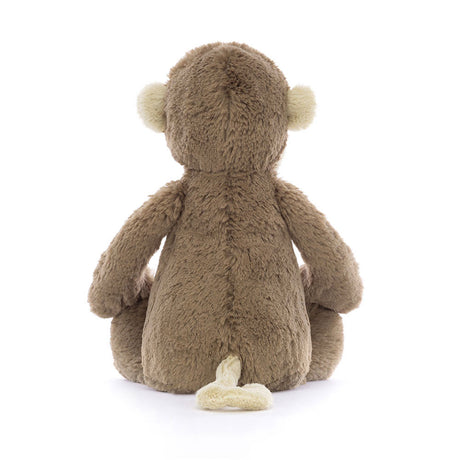 Soft brown plush Bashful Monkey Medium sitting with its back facing forward, showing cream-colored ears and tail, perfect as a toddler toy or stuffed animal gift.