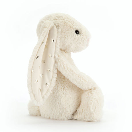 Bashful Twinkle Bunny plush toy sitting upright with soft cream-colored fur and ears decorated with silver star patterns, a perfect cuddly companion for children.