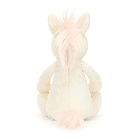 Bashful Unicorn Medium plush toy sitting with its back visible, featuring soft cream fur and light pink mane and tail, perfect as a kid’s birthday gift or stuffed animal.