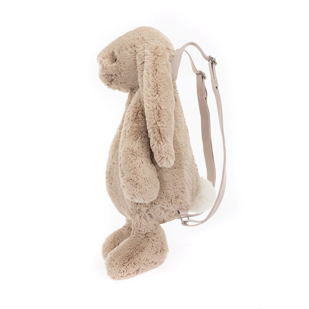 Side view of a soft, plush Bashful Beige Bunny Backpack with long floppy ears and adjustable straps, designed as a cute and cuddly accessory for kids.