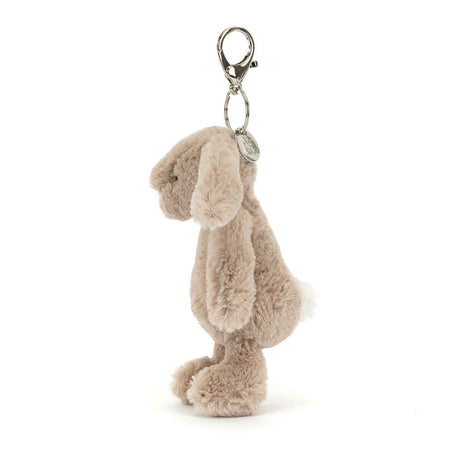 Soft plush beige bunny with floppy ears and a metal clasp for attaching to bags or keys, featuring the Bashful Beige Bunny Bag Charm.