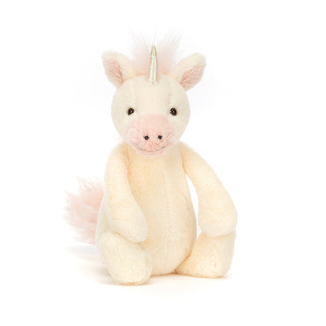 Bashful Unicorn Small is a soft, cream-colored plush unicorn with a pale pink snout, mane, and tail, featuring a shiny silver horn and friendly black eyes.