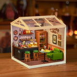 Miniature model of a Leisurely Cheers Bar with furniture and decor on a wooden surface.