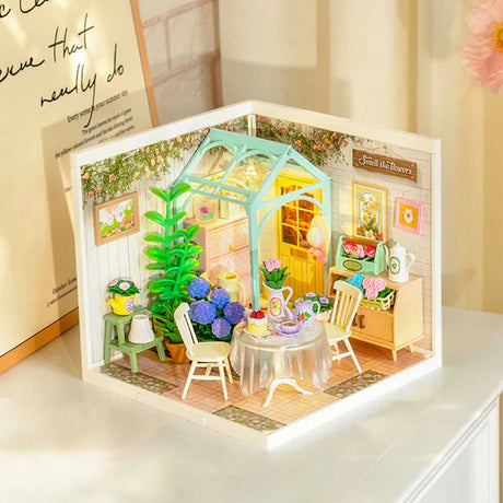Miniature model of a cozy room with furniture and decor, illuminated from within.