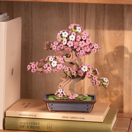 Sakura Bonsai DIY Wooden 3D Puzzle on top of books with a wooden shelf background
