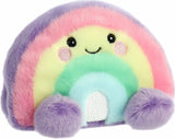 Pastel rainbow-shaped plush toy with a smiling face on a white background