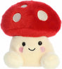 Plush toy with a red mushroom cap and smiling face on a white background