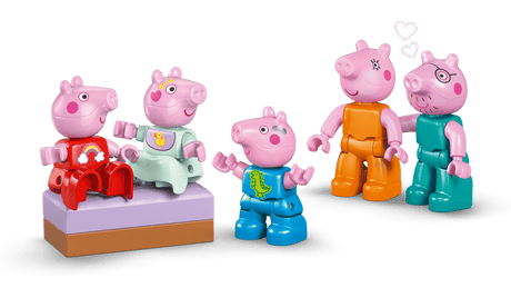 Five pink toy pigs in colorful outfits on a green background