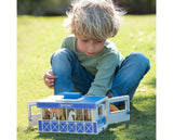 Child playing with a toy stable set on grass