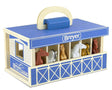 Breyer toy stable with horse figures on a white background
