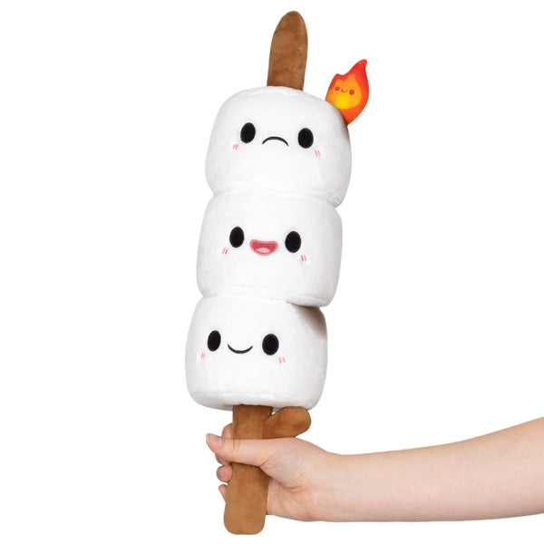 A hand holding a plush toy featuring three cute marshmallow characters stacked on a stick with a small flame detail, designed as Mini Comfort Food Marshmallows.