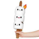 A hand holding a plush toy featuring three cute marshmallow characters stacked on a stick with a small flame detail, designed as Mini Comfort Food Marshmallows.