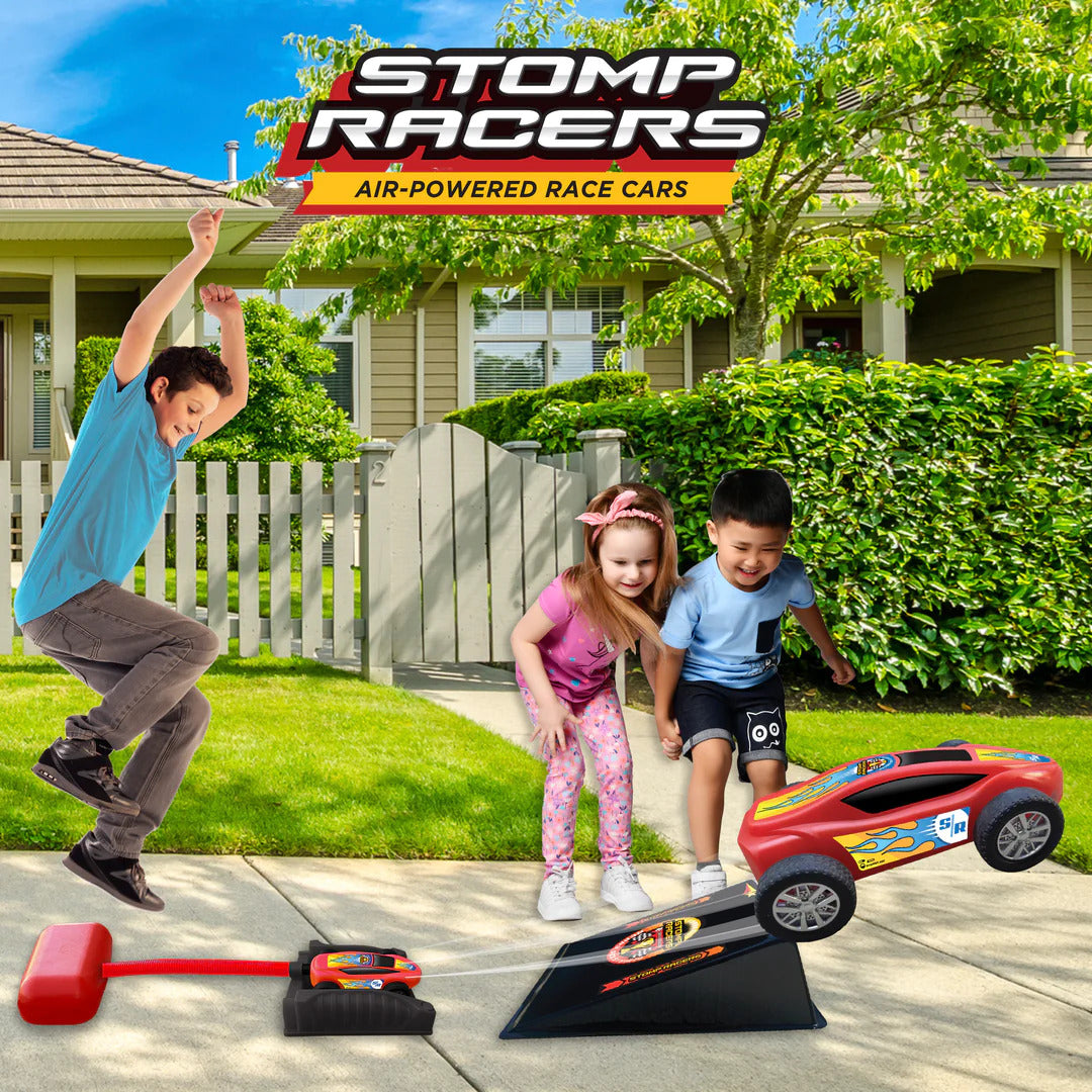 Children playing with Stomp Racers toy cars on a driveway in front of a house.