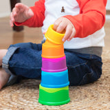 Child playing with colorful Dimpl Stack on a wooden floor