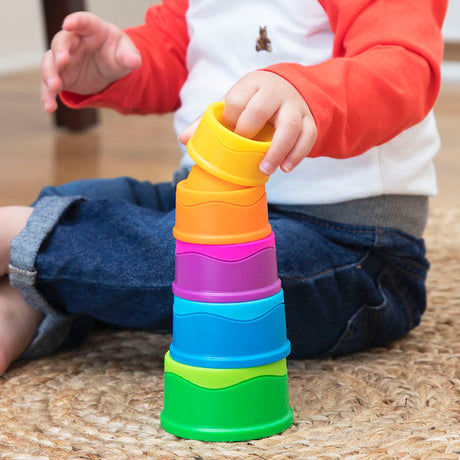 Child playing with colorful Dimpl Stack on a wooden floor