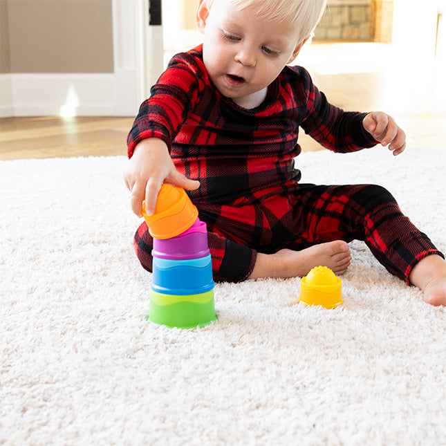 Child playing with colorfulDimpl Stack on a carpeted floor