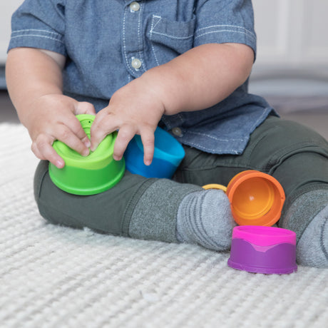 Child playing with colorful Dimpl Stack on a textured surface
