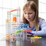 Child playing with a Trestle Tracks Deluxe Set on a table.