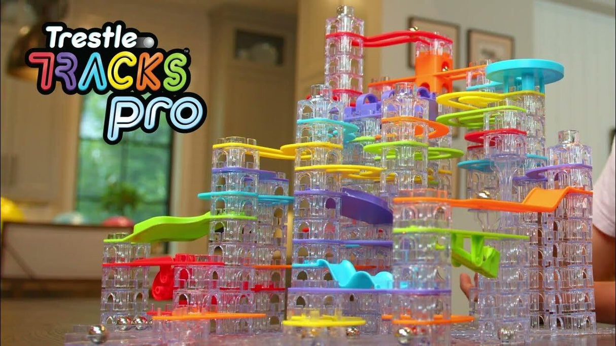 Colorful marble run track set with 'Trestle Tracks Pro' branding in a home setting.