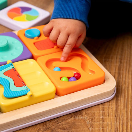 Child's hand interacting with a PlayTab Tiles Set 1 on a wooden surface