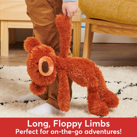 Child holding a large Pumpkin Pie Toothpick Bear, 15 In plush toy with long, floppy limbs on a carpeted floor.