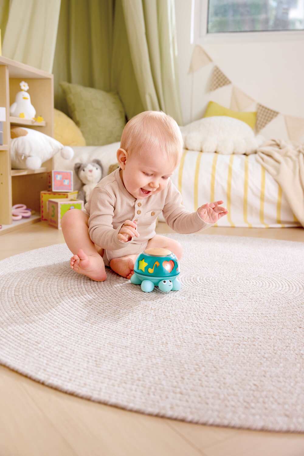 Baby playing with a Twist & Tune Turtle toy on a carpeted floor in a cozy room.