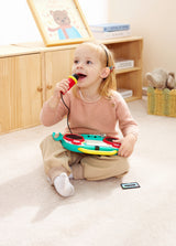 Child playing with a toy Sing-Along Pixel Boombox (Pixelz) in a room with wooden furniture.