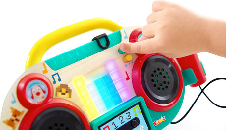 Colorful toy Sing-Along Pixel Boombox (Pixelz) with buttons and a hand interacting with it on a white background