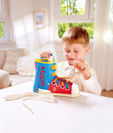 Child playing with a colorful Tie-It Lacing Sneaker in a bright room.