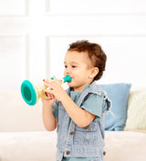 Child playing with a toy Musical Maestro Trumpet (Pixelz) indoors