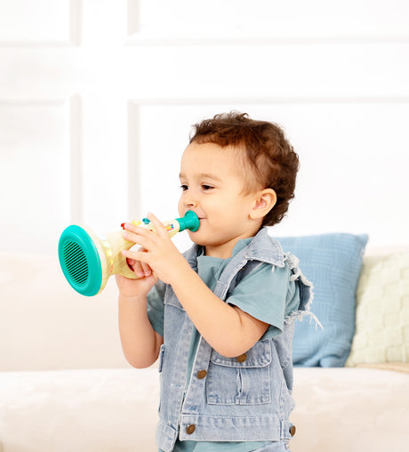 Child playing with a toy Musical Maestro Trumpet (Pixelz) indoors