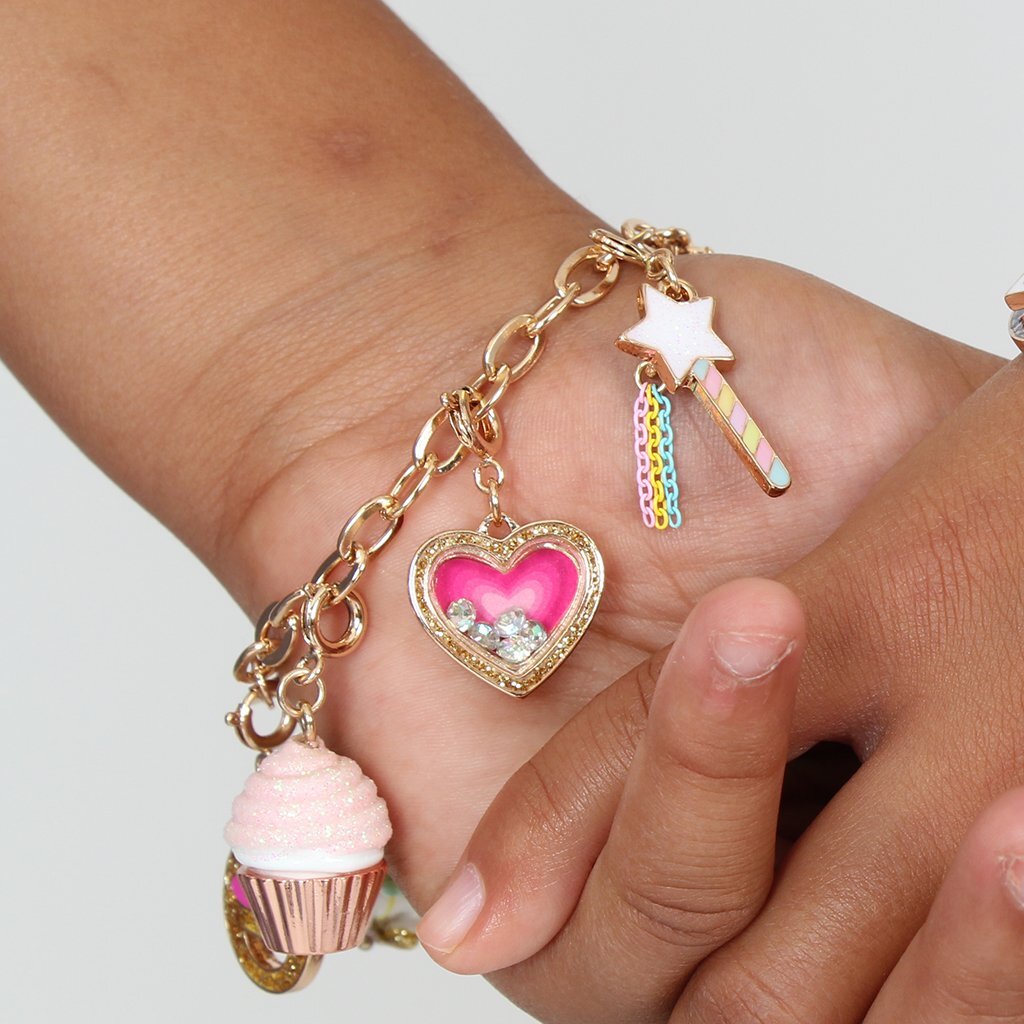 Bracelet with heart-shaped charm, star, and cupcake pendant on a wrist.