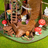 Fairytale Tree House DIY Miniature House with a log, mushrooms, and small figurines on a green surface.