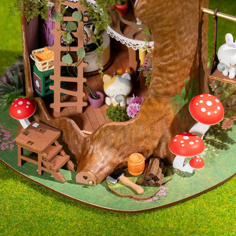 Fairytale Tree House DIY Miniature House with a log, mushrooms, and small figurines on a green surface.