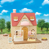 Toy Calico Critters - Village Cake Shop Starter Set with a pink roof and various display cases against a blue sky.
