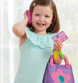 Young girl playing with toy phone and Kidoozie My First Purse against a light background