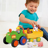 Child playing with a toy Funtime Tractor and animals on a white surface