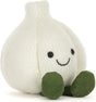 A Amuseables Garlic plush toy in off-white with olive green feet and a simple embroidered smiley face, photographed on a clean white background.